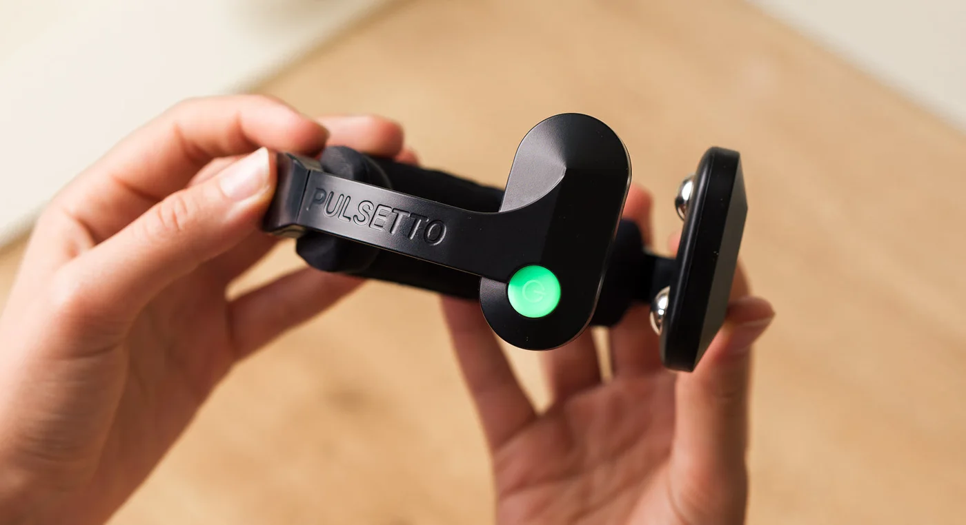 Hand holding the Pulsetto device before a session